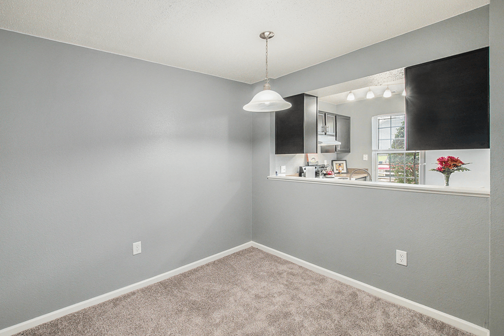 a bedroom with grey walls and a white pendant light hanging from the ceiling