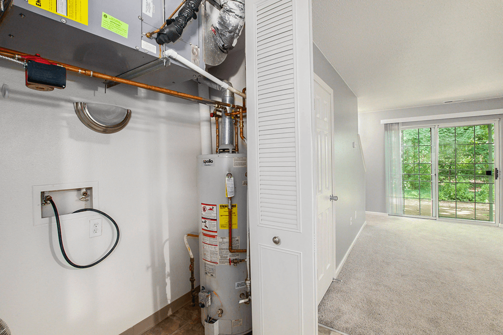 a gas boiler in a garage with a door to the outside