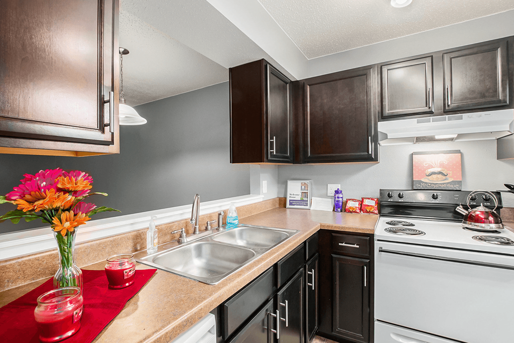 a kitchen with black cabinets and white appliances