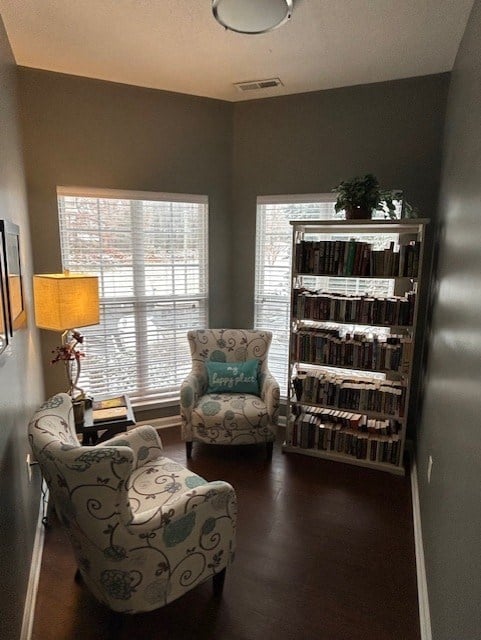 A living room with a chair, a sofa, a bookshelf, and a lamp.