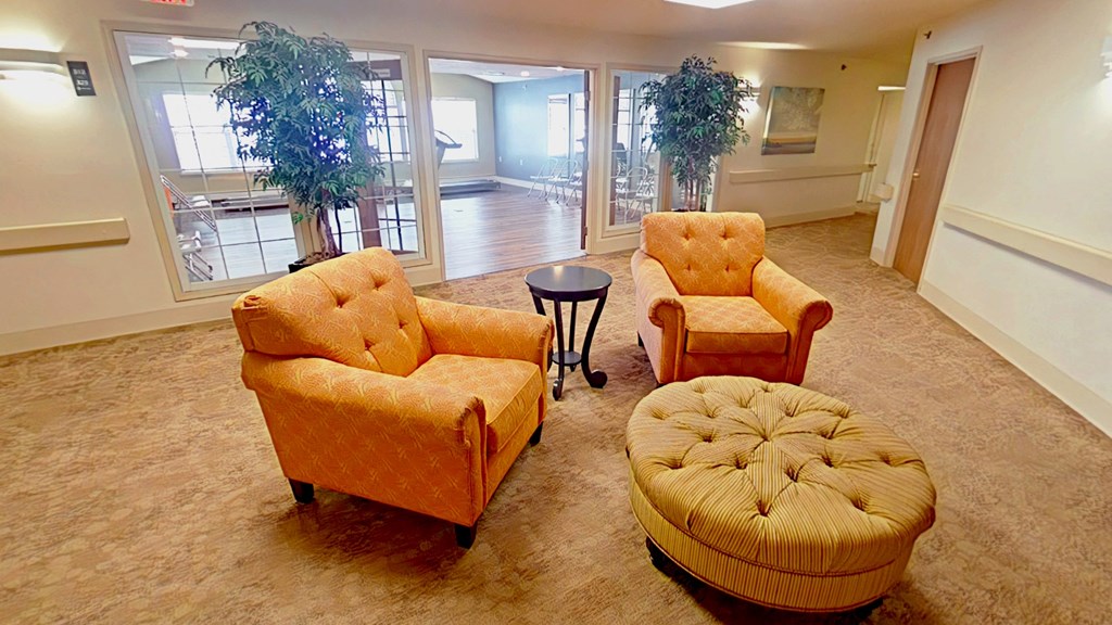 A living room with two chairs and a footstool.