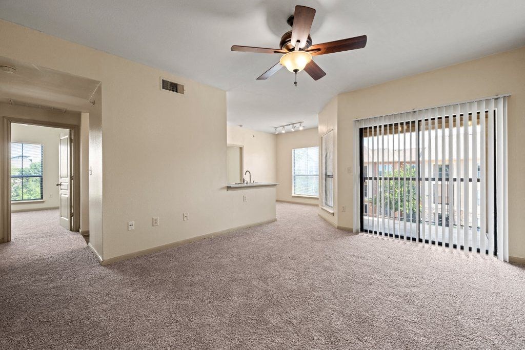 a large living room with a ceiling fan