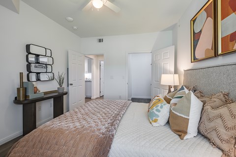 A bedroom with a large bed and a painting on the wall.