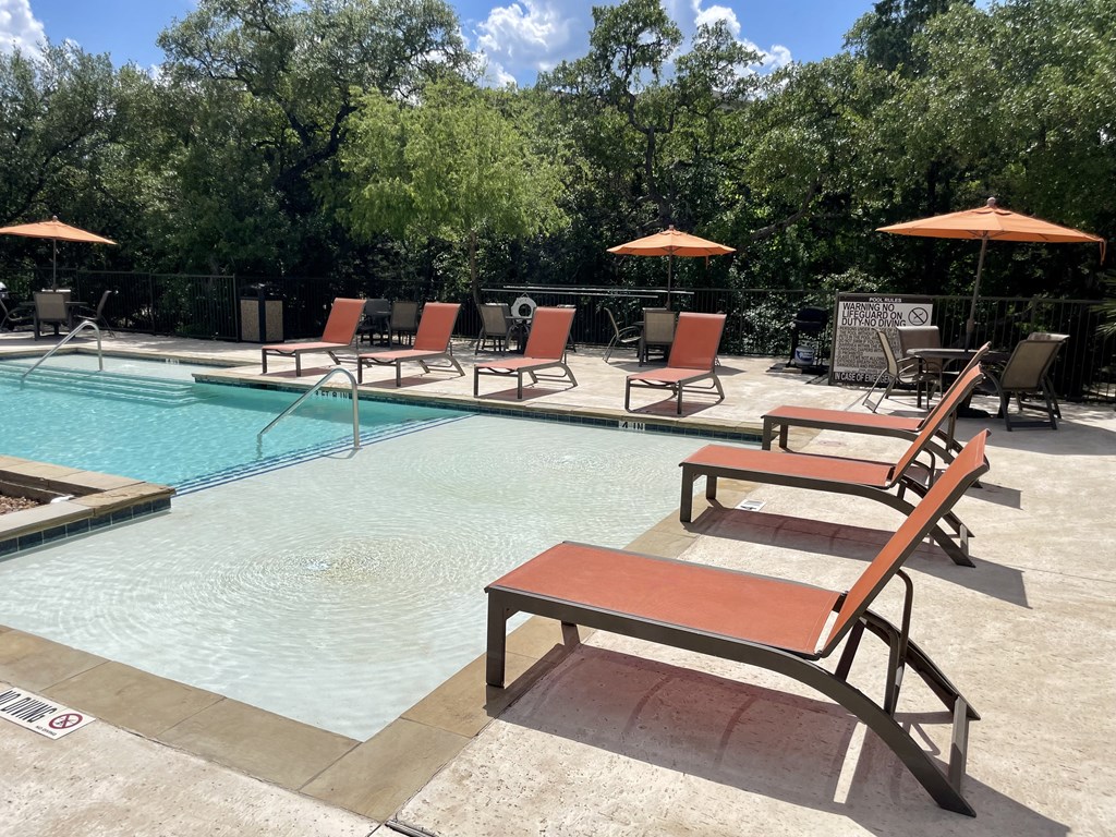 a pool with lounge chairs and umbrellas