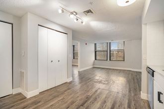 Spacious Open Concept Living Room with Hardwood Floors an empty living room and kitchen with white walls and wood floors