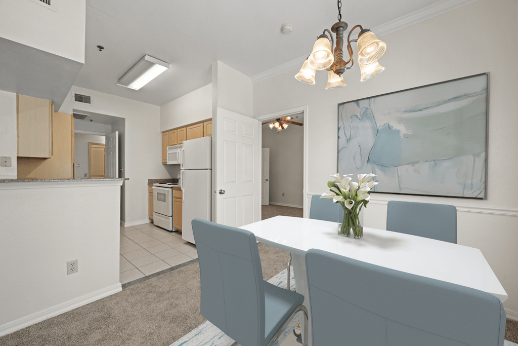 a dining room and kitchen with a white table and chairs