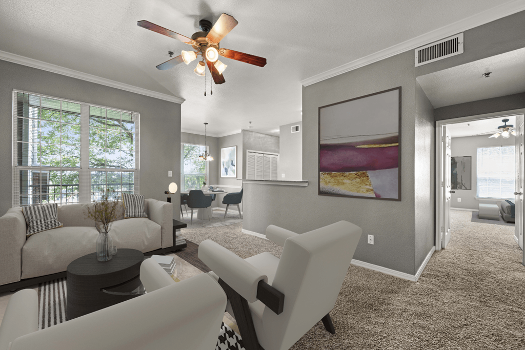 a living room with white furniture and a ceiling fan