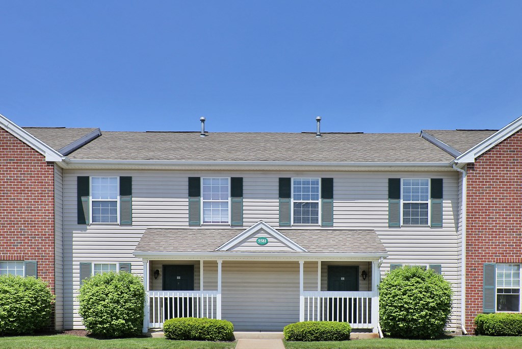a white house with green shutters and a blue sky