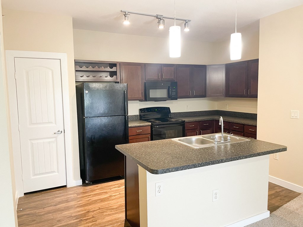 a kitchen with granite countertops and black appliances
