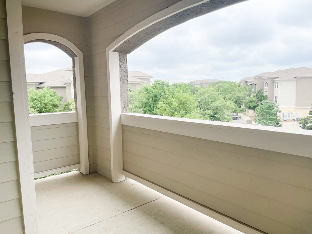 an arched window on a porch with a view of a neighborhood