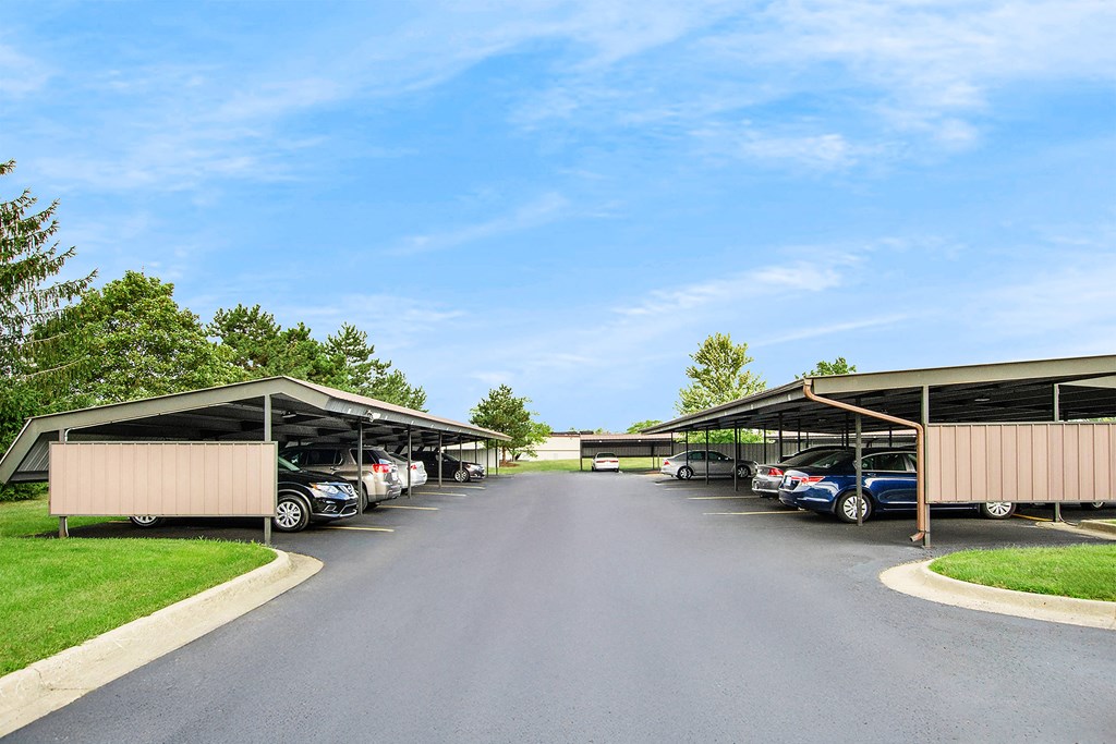 A parking lot with cars parked under a covered area.