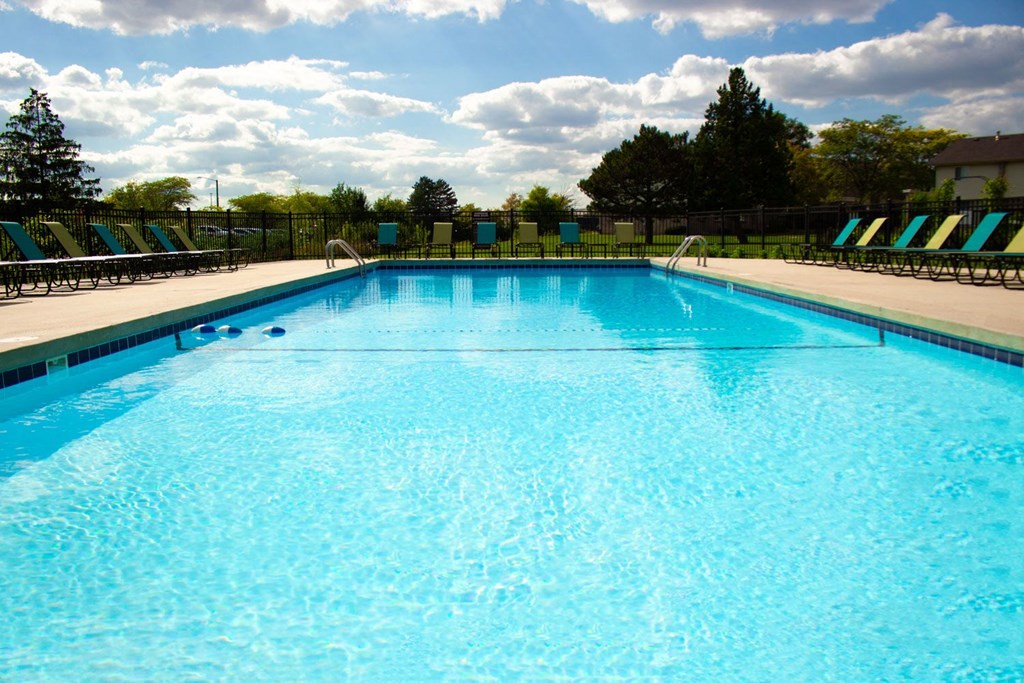 a large swimming pool with chairs around it