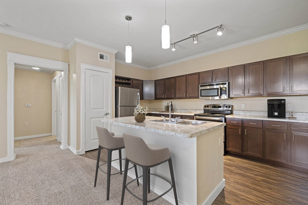 a kitchen with a large island with bar stools