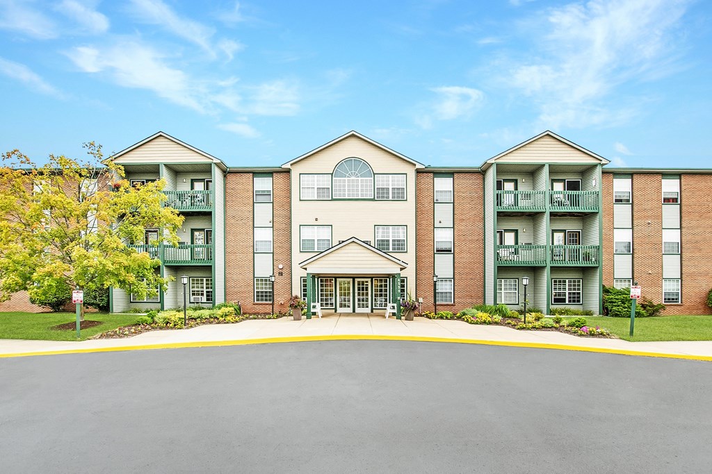 A large apartment complex with a central courtyard and a clear blue sky above.