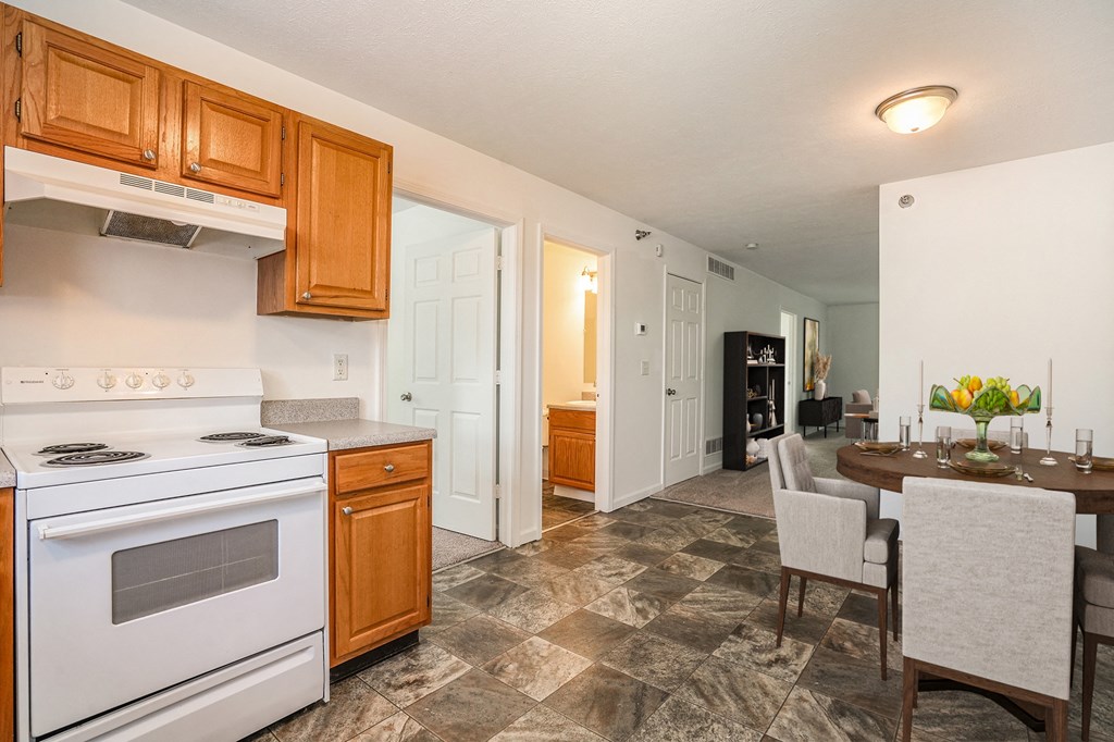 a kitchen and dining room with white appliances and wooden cabinets