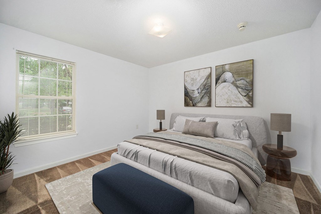 a bedroom with a bed and two paintings on the wall
