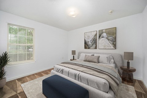 a bedroom with a bed and two paintings on the wall