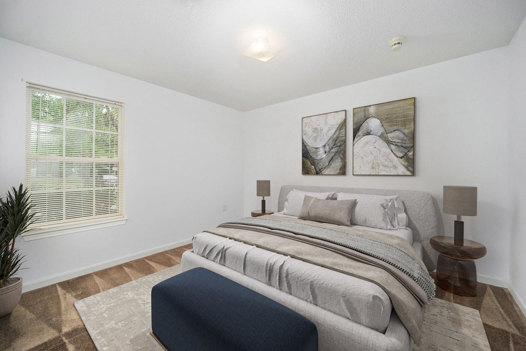 a bedroom with a bed and two paintings on the wall