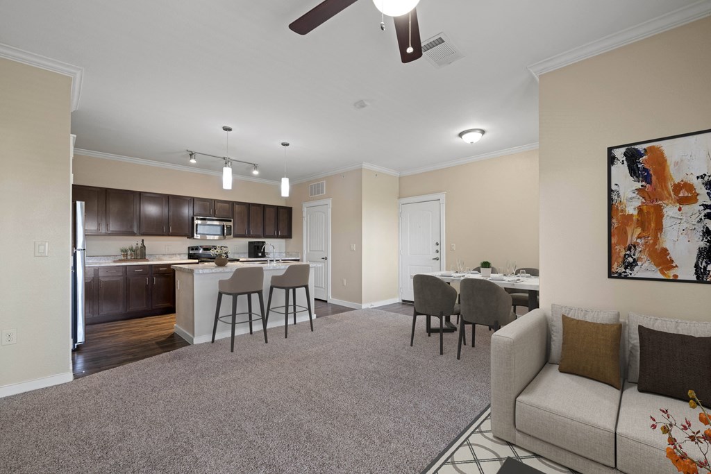 an open living room and kitchen with a couch and chairs