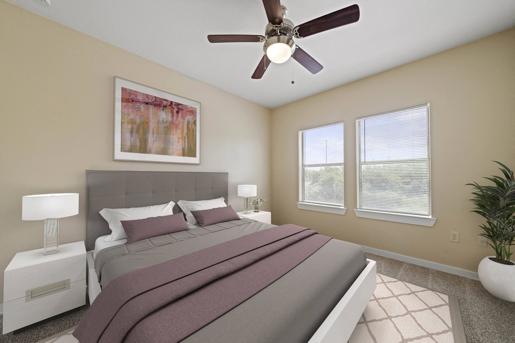 a bedroom with a large bed and a ceiling fan