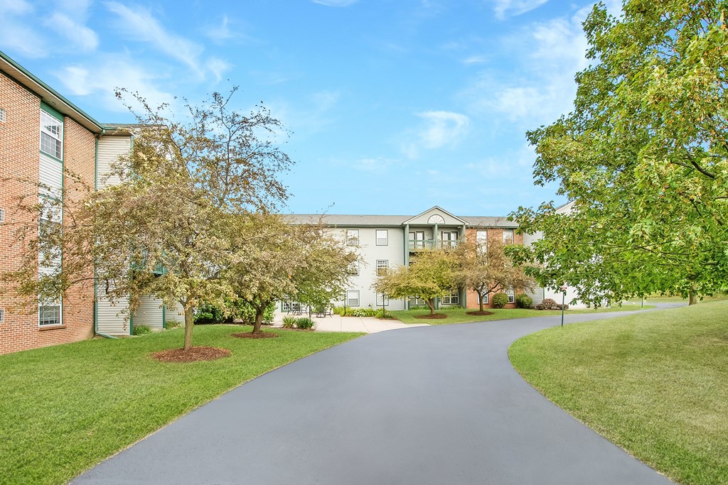 A long, straight road leads to a large building.