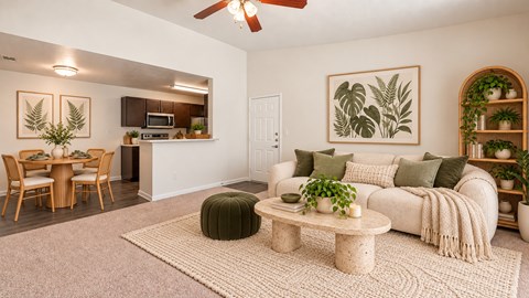 A living room with a white couch, a coffee table, and a ceiling fan.