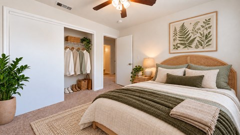 A bedroom with a large bed and a ceiling fan.