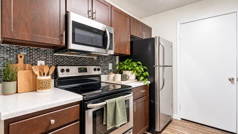 A kitchen with a stove, oven, microwave, and refrigerator.