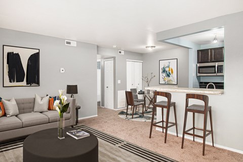 a living room with a couch and a kitchen with a bar