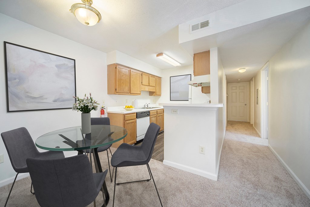 a dining room and kitchen with a glass table and chairs