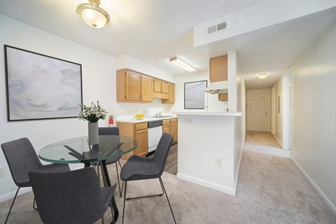 a dining room and kitchen with a glass table and chairs