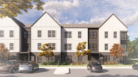 A modern building with a parking lot in front.