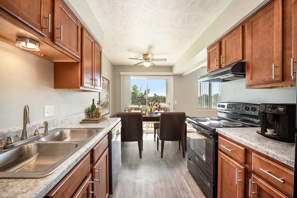 a kitchen and dining room with wooden cabinets and stainless steel appliances