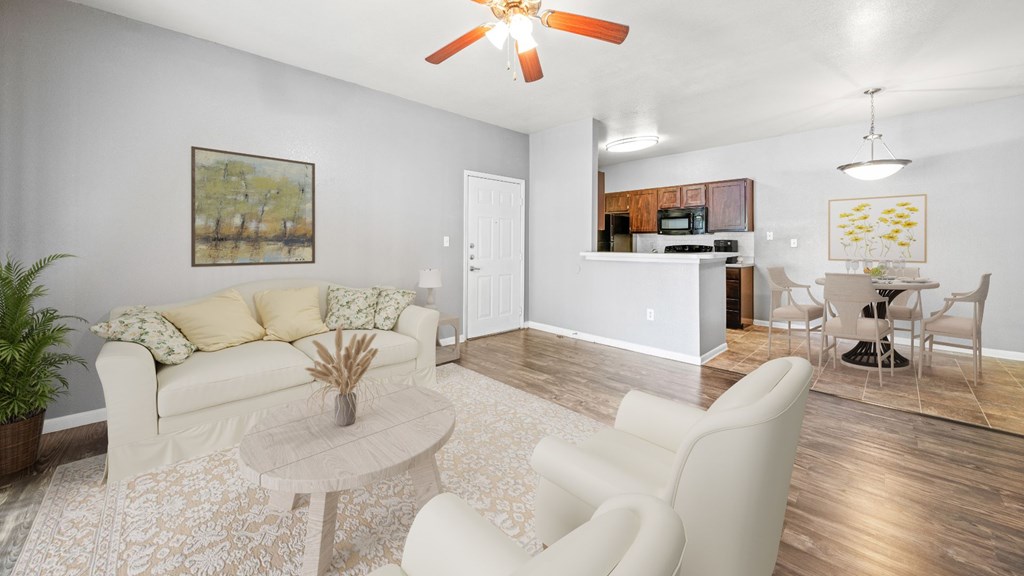 A living room with a white couch, a coffee table, and a ceiling fan.