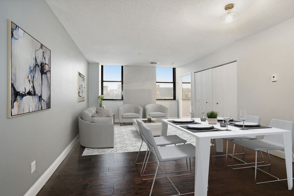 A modern dining room with a white table and chairs.
