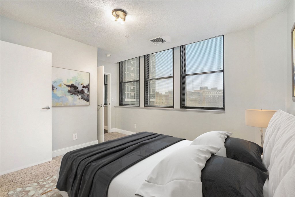 A bedroom with a large bed and a painting on the wall.