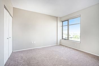 A room with a carpeted floor and a window.