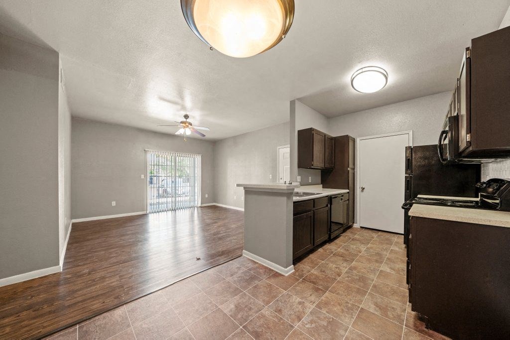 a kitchen and living room with a sliding glass door to a patio
