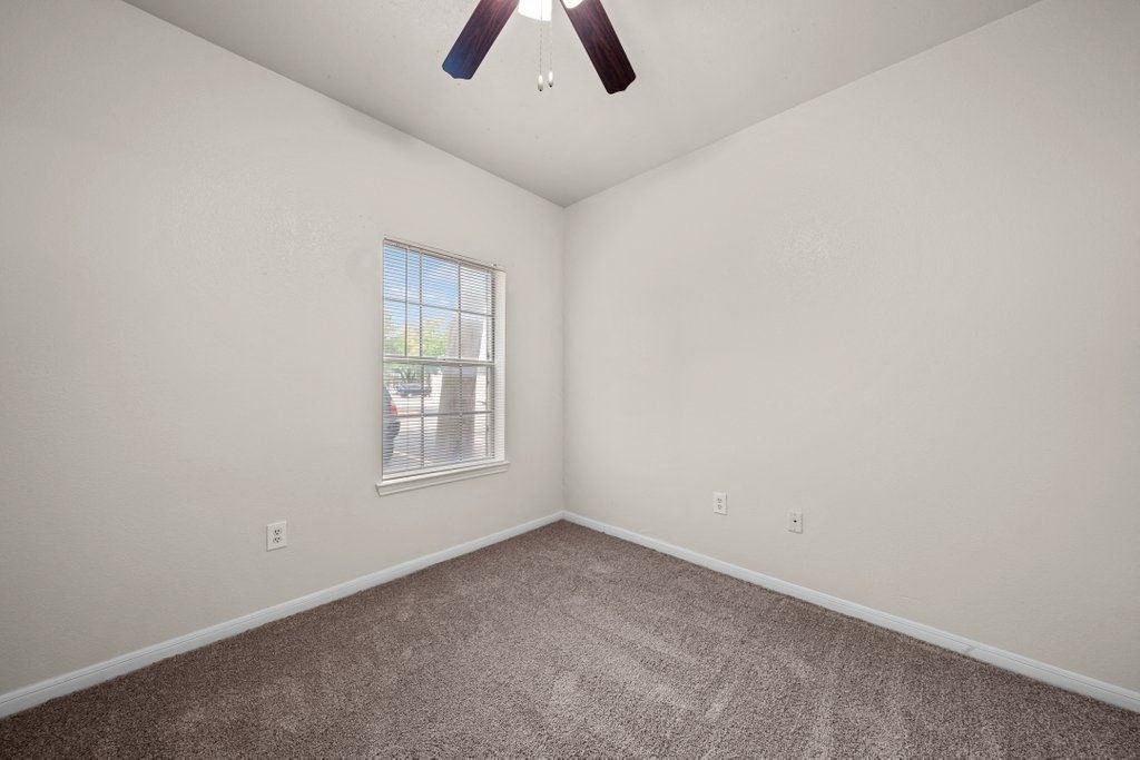 a bedroom with a ceiling fan and a window