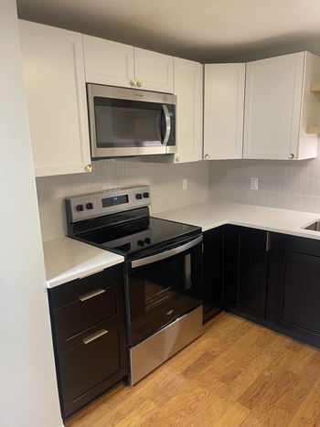 A kitchen with a stove and microwave.