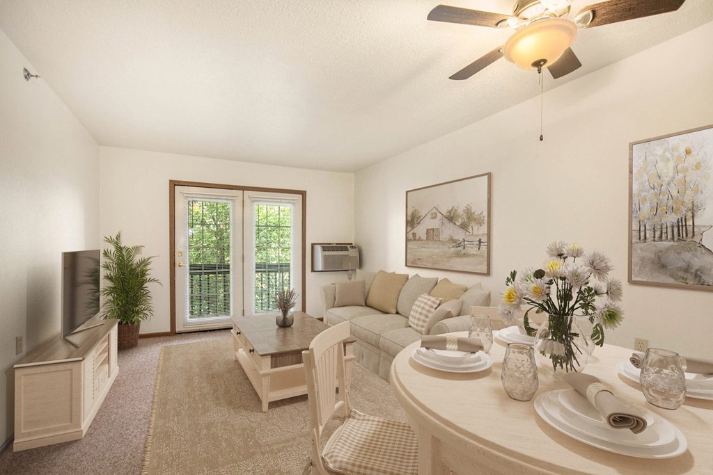 A dining room with a table set for two and a ceiling fan.