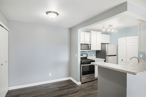 a kitchen with white cabinets and stainless steel appliances
