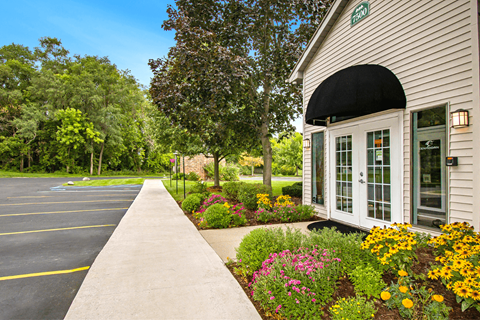the front of a building with a flower garden in front of it