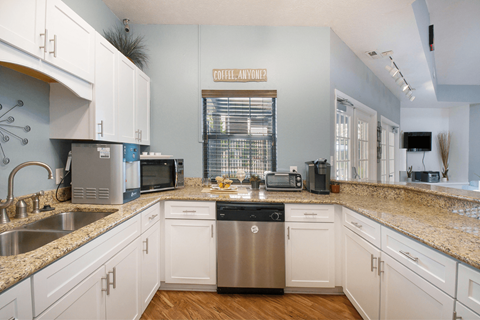 a kitchen with white cabinets and a granite counter top