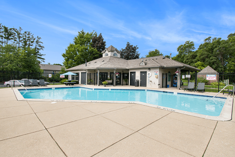a swimming pool with a clubhouse in the background