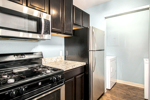 a kitchen with black cabinets and stainless steel appliances