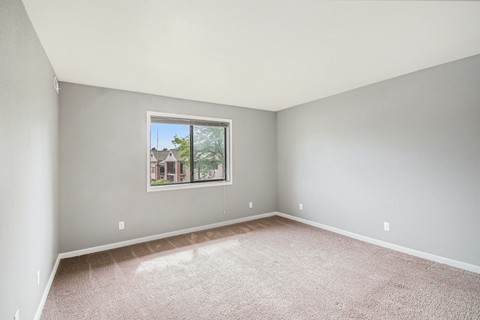 a bedroom with gray walls and a large window