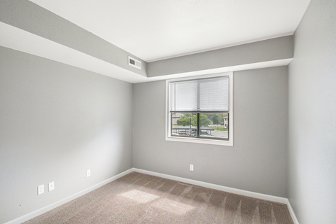 an empty bedroom with a large window