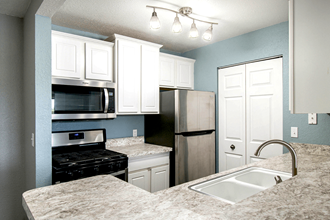 a kitchen with white cabinets and blue walls