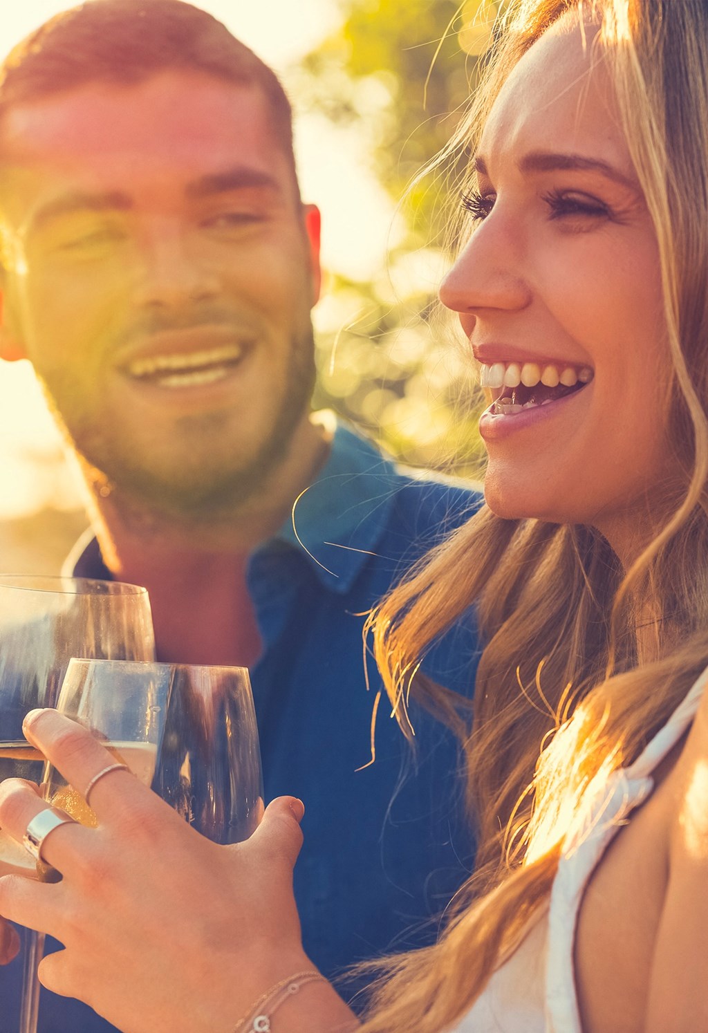 a man and a woman holding wine glasses and smiling